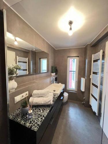 a bathroom with a tub and a sink and a toilet at Urban Charm Design Loft in Koblenz