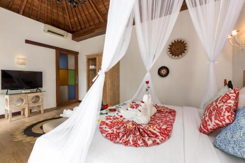 Schlafzimmer mit einem Bett mit Moskitonetz in der Unterkunft Ubud Raya Villa in Ubud