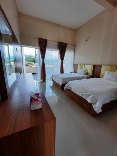 a hotel room with two beds and a table at Yulides home gardens in Cindakir