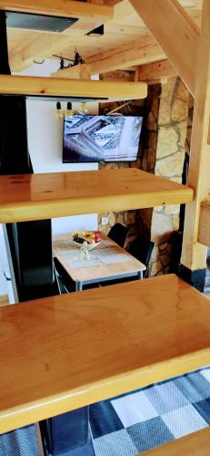 a table and benches in a room with a tv at Brvnara Tarska Zora in Sekulić 