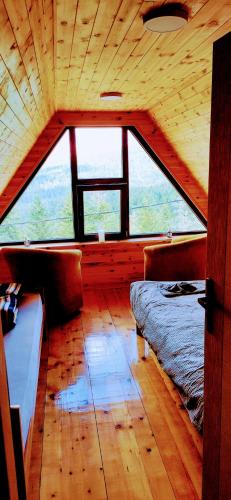 a room with a bed and a large window at Brvnara Tarska Zora in Sekulić 
