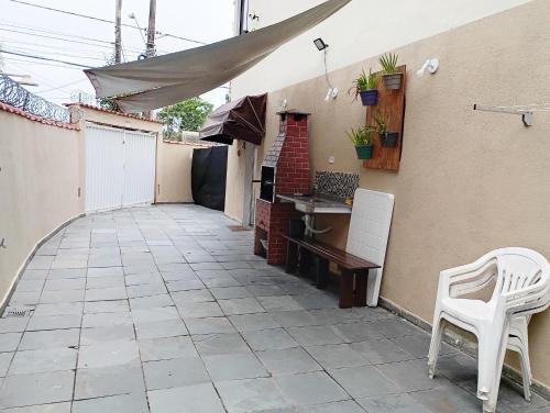 een patio met een tafel en een stoel naast een gebouw bij Espaço Mar Doce Lar - Praia Indaiá e Riviera in Bertioga