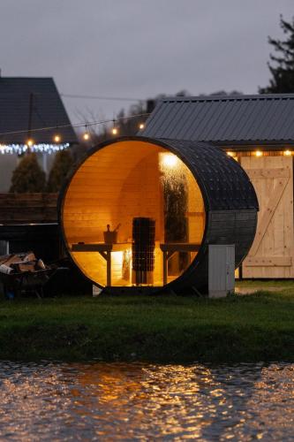 a round house is sitting on the grass near the water at Daczowisko in Gruczno