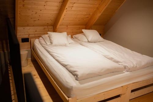 a large white bed in a wooden room at Daczowisko in Gruczno