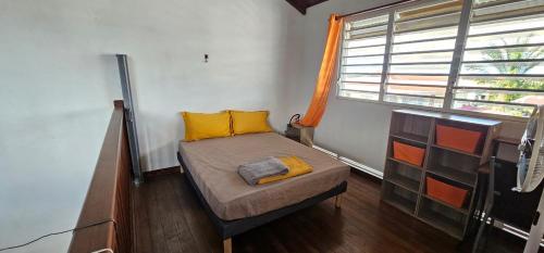 een kleine slaapkamer met een bed en een raam bij DOWNTOWN LOFT in Saint-Laurent du Maroni