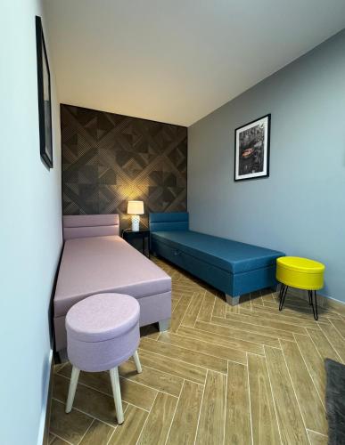 a room with a bed and a bench and a table at Apartament Ula in Nysa