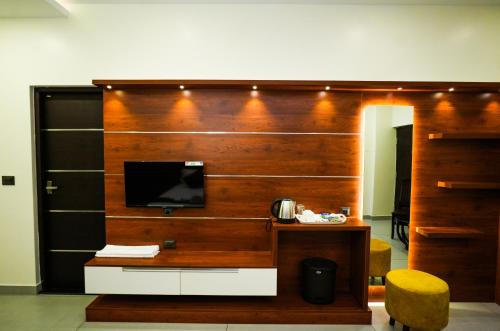 hotel 24inn residency في Pathanāmthitta: غرفة بها جدار مع تلفزيون ومكتب