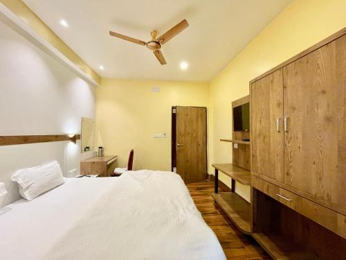 Schlafzimmer mit einem Bett und einem Deckenventilator in der Unterkunft Hotel SHIVAM ! Varanasi Forɘigner's-Choice ! fully-Air-Conditioned-hotel, lift-and-Parking-availability near-Kashi-Vishwanath-Temple and-Ganga-ghat in Varanasi