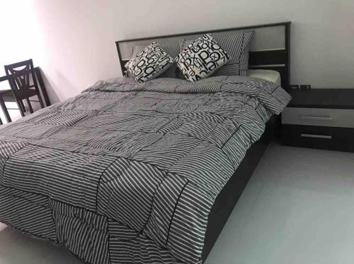 Una cama blanca y negra con almohadas. en Cosy studio in a new building -Brand New nice view, en Dubái