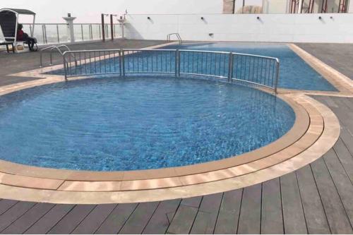 una gran piscina con agua azul en un patio en Cosy studio in a new building -Brand New nice view, en Dubái