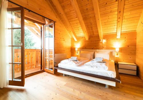 a bedroom with a bed in a wooden house at 1A Chalet Koralpe Wandern, Grillen mit Sauna und Wellness in Hartelsberg