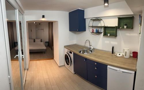 a kitchen with a sink and a washing machine at City Centre One in Skopje