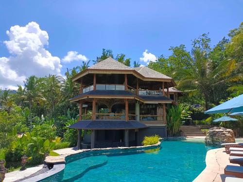 ein Haus mit einem Pool vor einem Resort in der Unterkunft Sunrise Paradise Bali in Karangasem