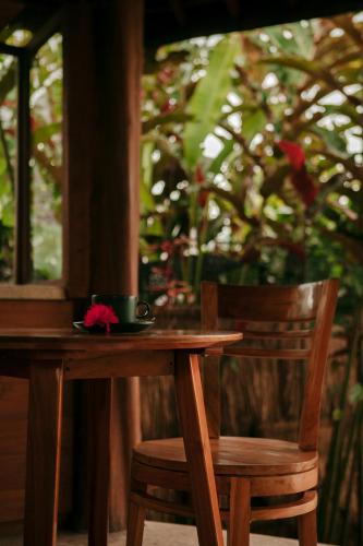a wooden table with two chairs and a cup on it at Sunrise Paradise Bali in Karangasem