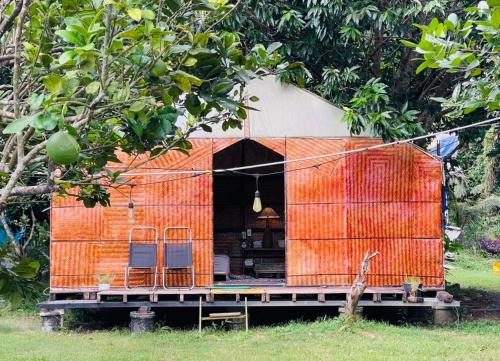 an orange house with chairs in the middle at Con Dao Backpacker - LoCo Camping in Con Dao