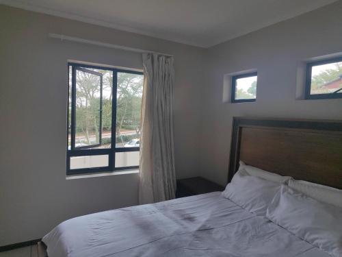 a bedroom with a bed and a window at Home far away from Home in Roodepoort