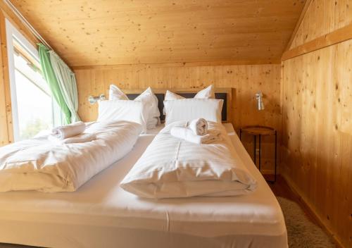 1 dormitorio con 2 camas con sábanas blancas y ventana en 1A Chalet "Wolke" Ski und Wellness im Traumhaus, en Wolfsberg