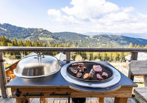 a grill with meat and a pot on a table at 1A Chalet "Wolke" Wandern, Grillen, Wellness im Traumhaus in Wolfsberg