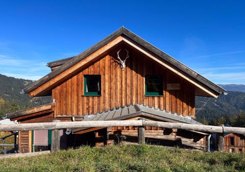 a large wooden building on a hill with mountains in the background at 1A Chalet "Wolke" Wandern, Grillen, Wellness im Traumhaus in Wolfsberg