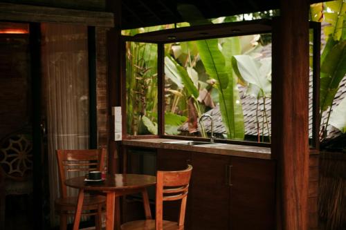 a table and chairs in front of a fish tank at Sunrise Paradise Bali in Karangasem