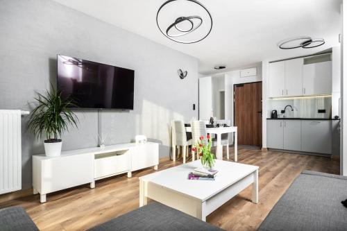 ein Wohnzimmer mit einem Wohnzimmer in der Unterkunft Capital Apartments in Krakau