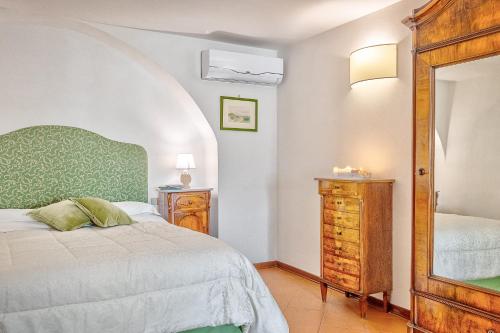- une chambre avec un lit, une commode et un miroir dans l'établissement La Torretta - Together in Tuscany, à Cortone
