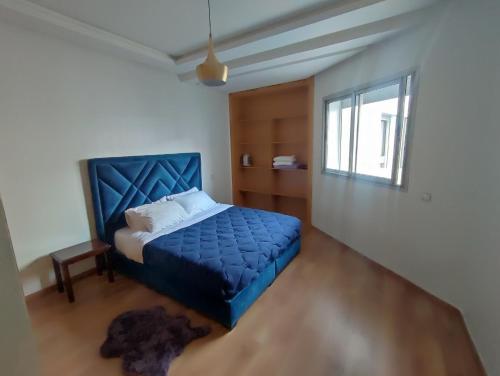 a bedroom with a blue bed and a window at Studio La gironde in Casablanca