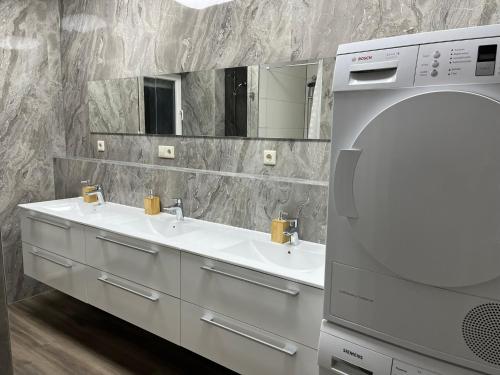 施韋比施哈爾的住宿－HausOase Zimmervermietung，一间带两个盥洗盆和大镜子的浴室