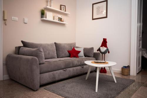 a living room with a gray couch and a table at Apartment HYGGE in Subotica