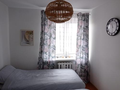 a bedroom with a bed and a window with a chandelier at Paprotka in Radków