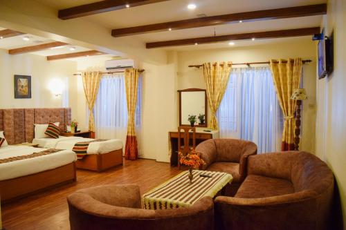 a hotel room with two beds and two chairs at Kathmandu Prince Hotel in Kathmandu