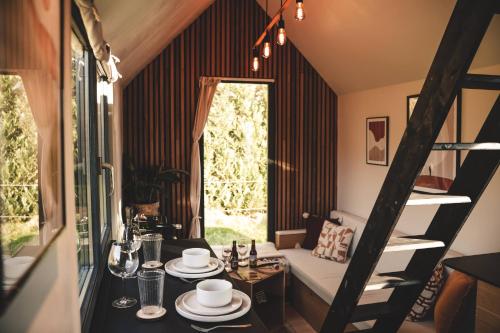 a room with a table and a couch and a window at Tiny House Au Coeur de la Campagne Wallonne in Chaumont-Gistoux