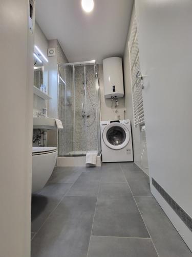 ein Bad mit einer Waschmaschine und einer Dusche in der Unterkunft Mek lux Bjelasnica in Bjelašnica