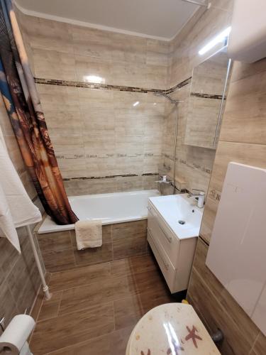 y baño con bañera, aseo y lavamanos. en Mádi Rezidencia en Budapest