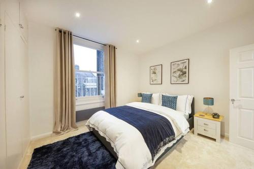 - une chambre avec un grand lit et une fenêtre dans l'établissement Stunning Hyde Park Apartment, à Londres