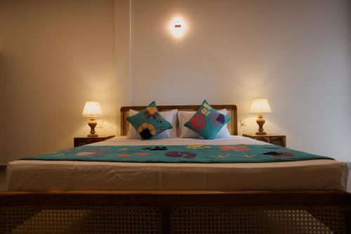 a bedroom with a large bed with two lamps at Coop Safari Hotel in Tissamaharama