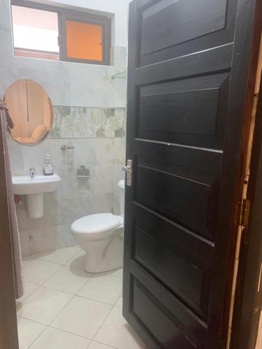 a bathroom with a toilet and a sink at Moraa’s Home in Mombasa