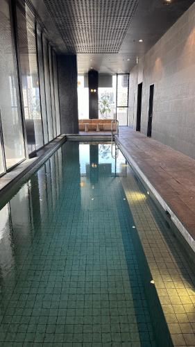 an empty swimming pool in a building at Nest Apartments MEET Empire in Melbourne