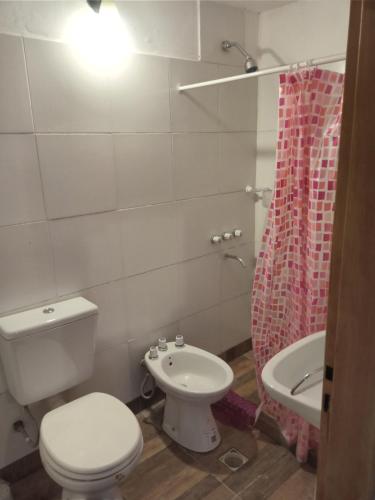 a bathroom with a toilet and a sink and a tub at La Protegida in El Chalten