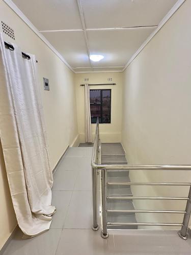 a hospital hallway with white walls and a stair case at Chalala Apartment in Lusaka