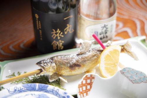 un pesce su un piatto con una fetta di limone di Ichimaru Ryokan - Vacation STAY 35990v a Tenkawa