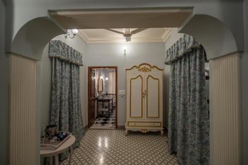 a hallway with an archway with curtains and a bathroom at Cavalry Villa bikaner in Bikaner