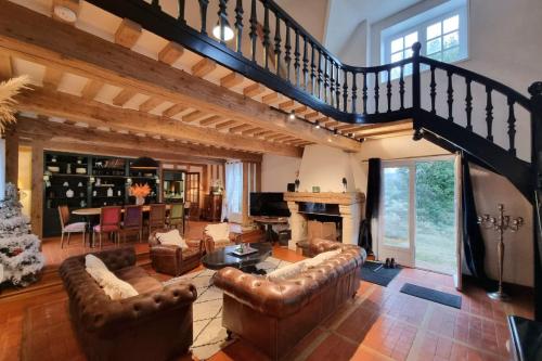 a living room with leather furniture and a staircase at Maddalena - Charming country villa for 10 people in Barneville-la-Bertran