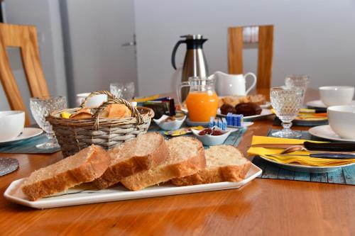 a table with a plate of bread and toast at Chambres D’hôtes Any-Jean Louis à Mios in Mios