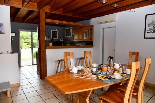 a kitchen and dining room with a wooden table and chairs at Chambres D’hôtes Any-Jean Louis à Mios in Mios