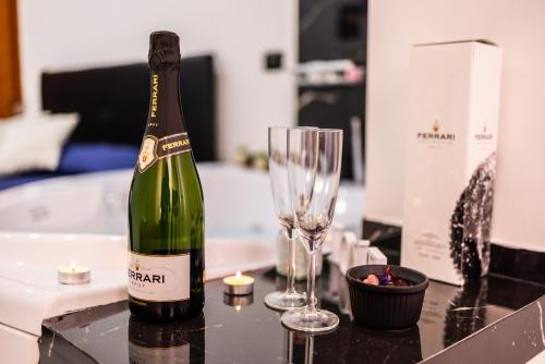a bottle of champagne and a wine glass on a counter at SUITE CELESTIA CASORIA By Suite in Casoria