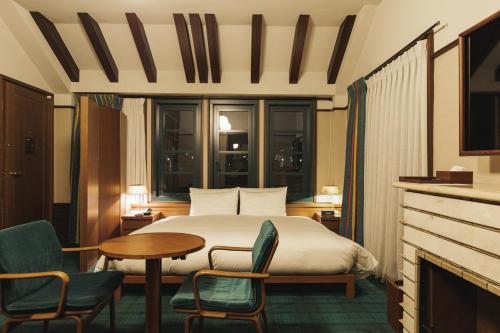 a hotel room with a bed and a table and chairs at Marufukuro in Kyoto