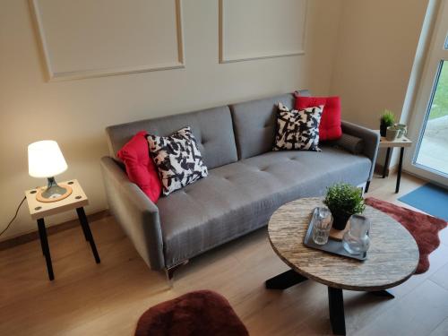 a living room with a couch and a table at Apartament Prezydencki na Letniej 71m2 z Ogrodem i Widokiem na Góry Kłodzko - Przyjaciół Ziemi Kłodzkiej in Kłodzko