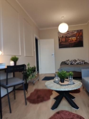 a living room with a bed and a table at Apartament Prezydencki na Letniej 71m2 z Ogrodem i Widokiem na Góry Kłodzko - Przyjaciół Ziemi Kłodzkiej in Kłodzko
