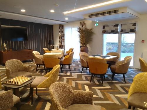 a waiting room with chairs and tables and a television at Domitys L'Ellipse in Paris